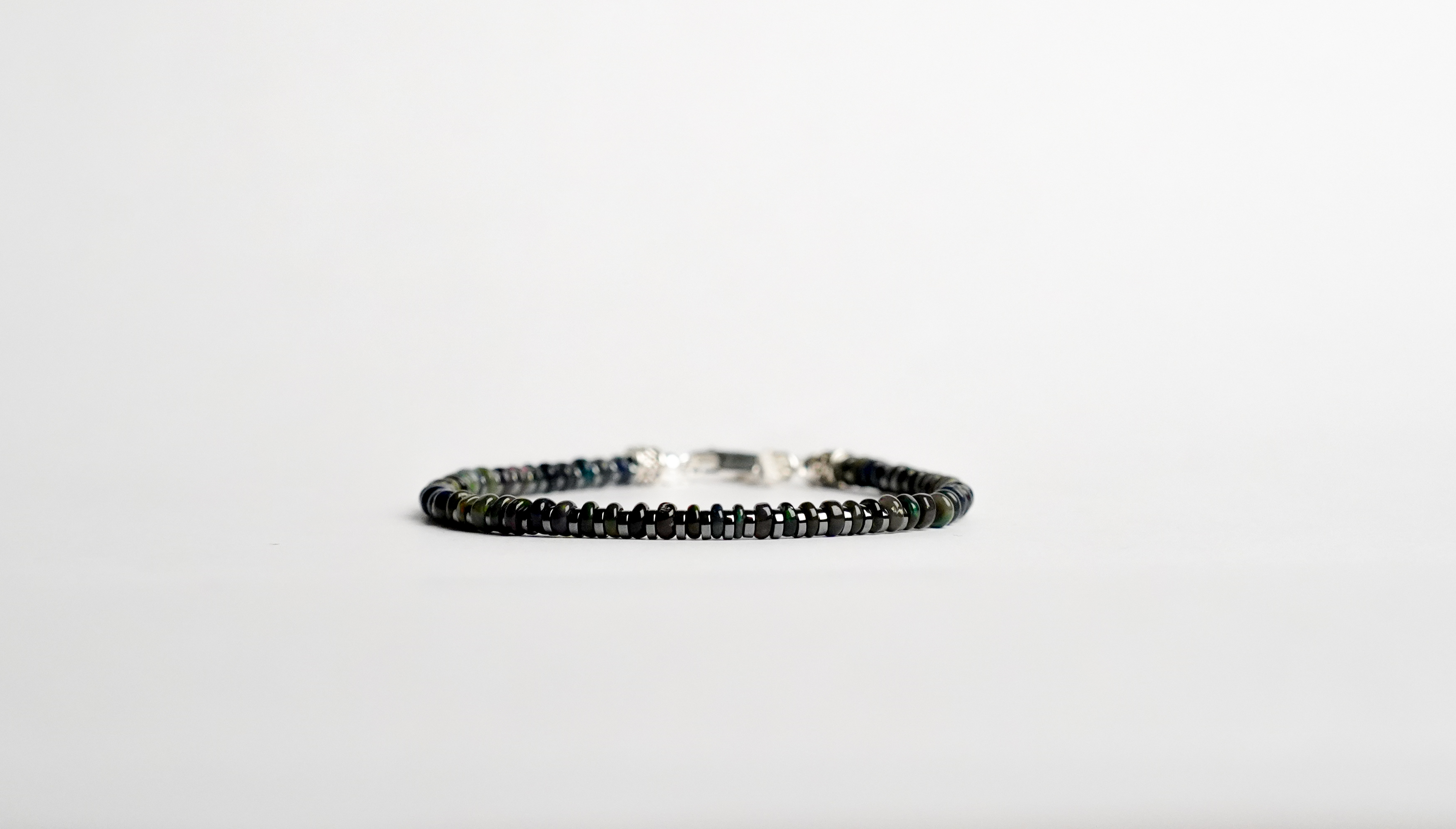 Il bracciale è realizzato con Opale nero etiope, ematite e rifinito con accenti in Argento sterling 925 e pratica chiusura a moschettone in Argento sterling 925. Un gioiello unico ed irripetibile. Fatto completamente a mano in Italia.