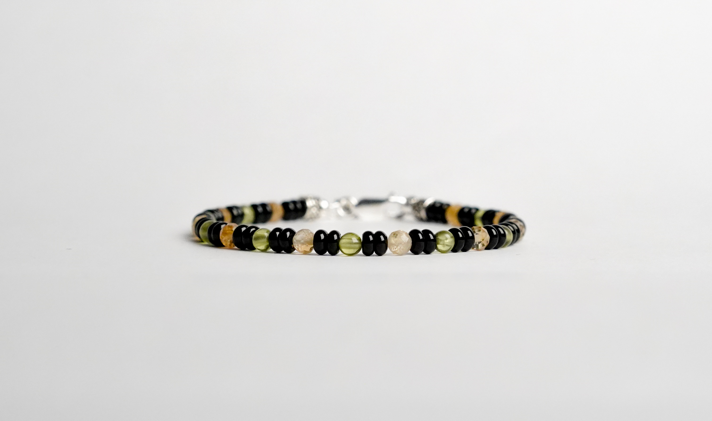 Il bracciale è realizzato con perle di Citrino, Peridoto e Onice nero. Rifinito con accenti in Argento sterling 925 e pratica chiusura a moschettone in Argento sterling 925. Fatto completamente a mano in Italia.