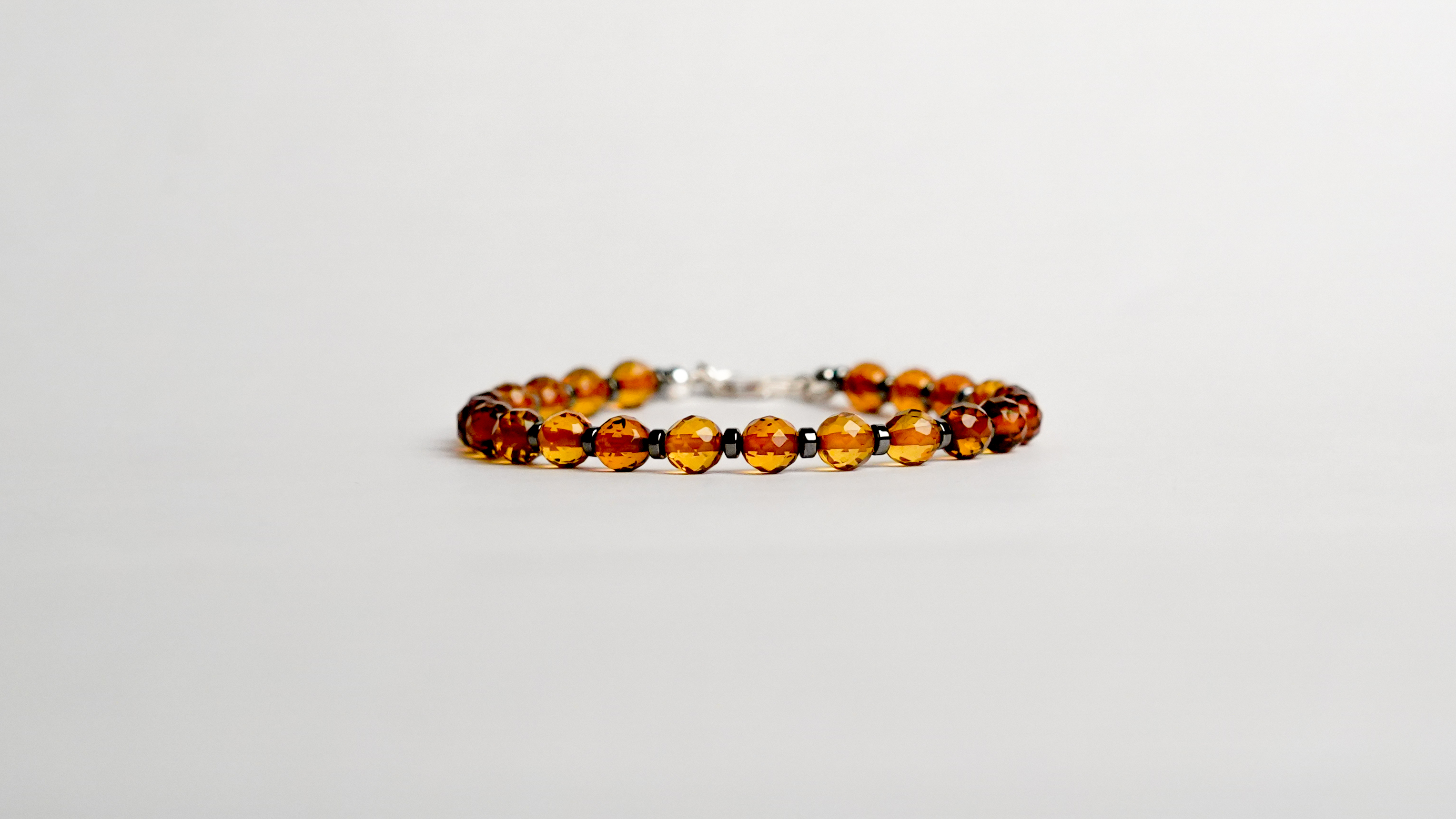 l bracciale è realizzato con gemme di Ambra baltica sfaccettate color cognac ed ematite.