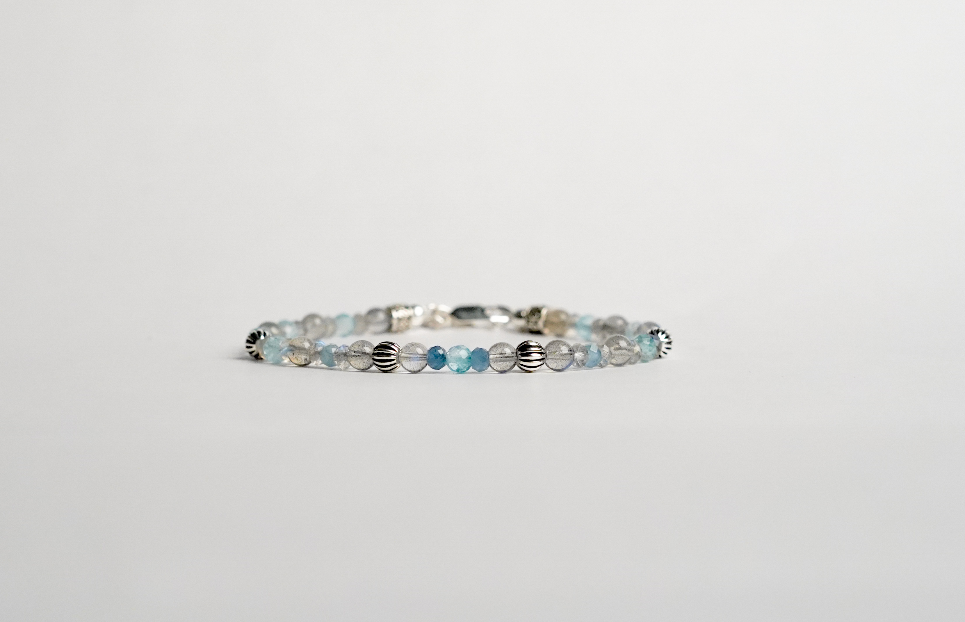 Il bracciale è realizzato con perle e gemme di Labradorite, Acquamarina Santamaria e Topazio svizzero. Rifinito con accenti in Argento sterling 925 e pratica chiusura a moschettone in Argento sterling 925. Realizzato con le gemme più belle per un gioiello dal fascino unico e contemporaneo. Fatto completamente a mano in Italia.