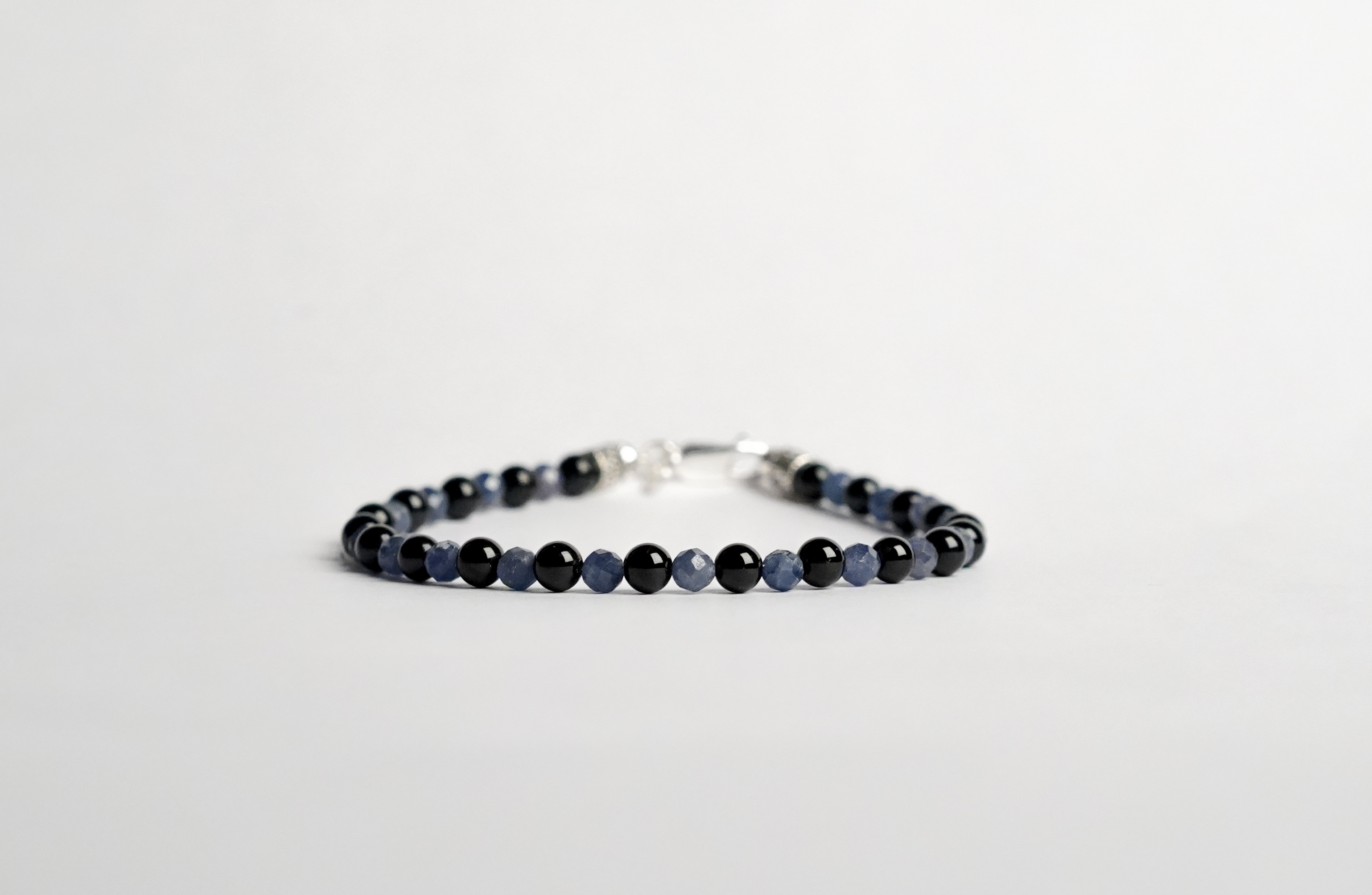 Il bracciale è realizzato con perle di Tormalina nera e gemme di Zaffiro blu.