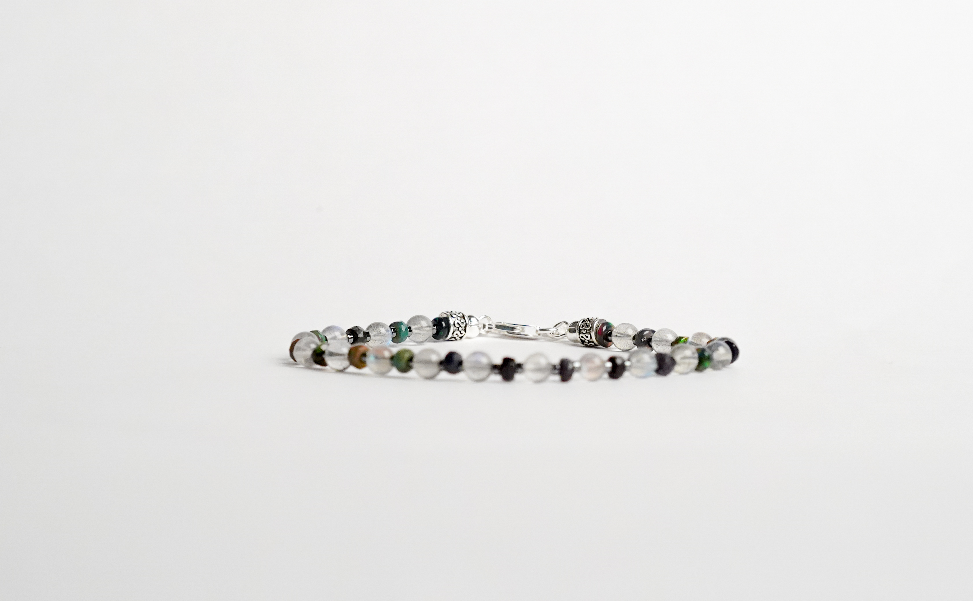 Il bracciale è realizzato con perle di Labradorite, Opale nera etiope ed ematite.